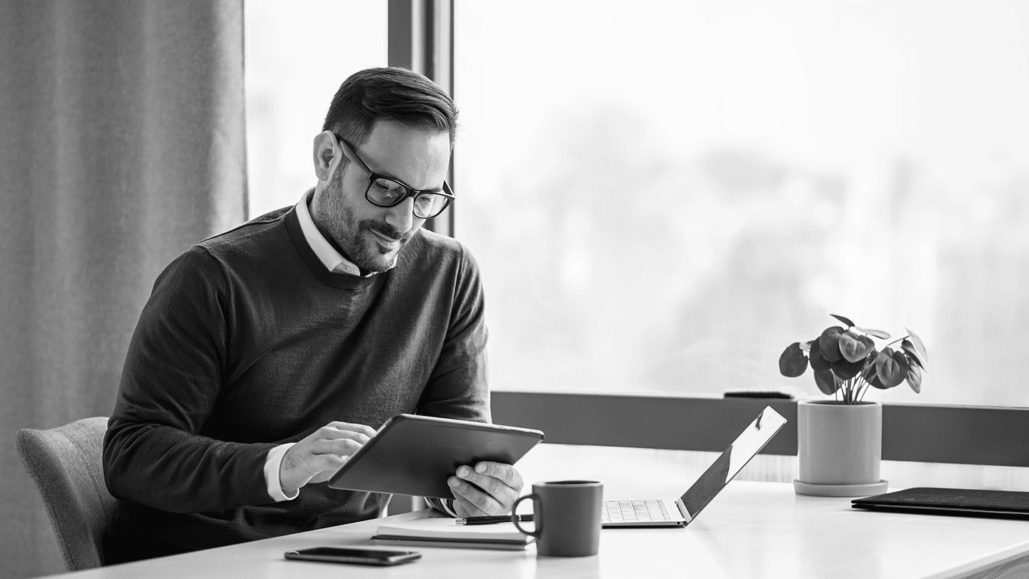 A man in spectacles on a tablet