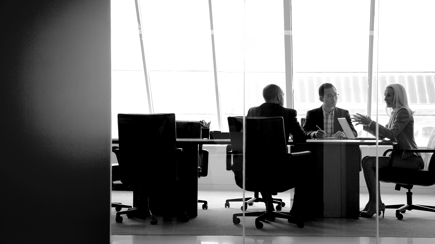 Two male and one female colleague in a boardroom